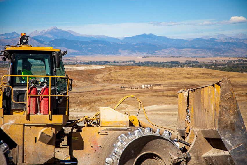 Photo of man operating a front end loader in landfill.