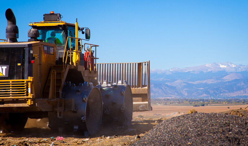 Photo of waste compactor covering waste.